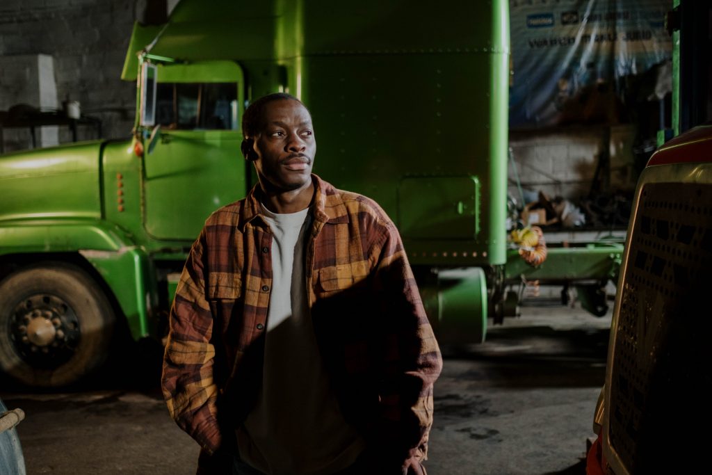 Truck driver at truck stop with green truck